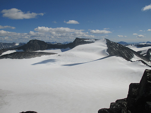 På eggen mellom Storjuvtind og Ymelstind med utsikt mot Svellnosbreen med sin brehest og de to Tverråtindane