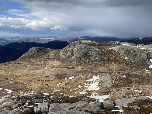 Nedstigning frå Krunefjell med utsikt mot Salane og Øvre Daurmålsknuten. Det er tett og går byger innover i Årdal