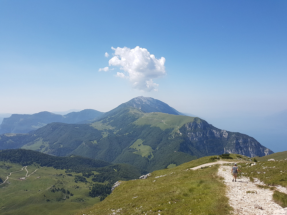 Ned igjen. Monte Baldo dominerer. Sadel Monte Altissimo på skogkledd rygg nede høyre. Bilveien opp nordryggen av Monte Baldo forbudt for motorkjøretøyer..