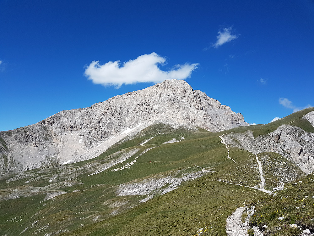 Ruter Corno Grande: "Direttissima" rett opp sørflanken mot toppen, "Normale" ut til venstre og bak vestryggen via nordflanken til topps.