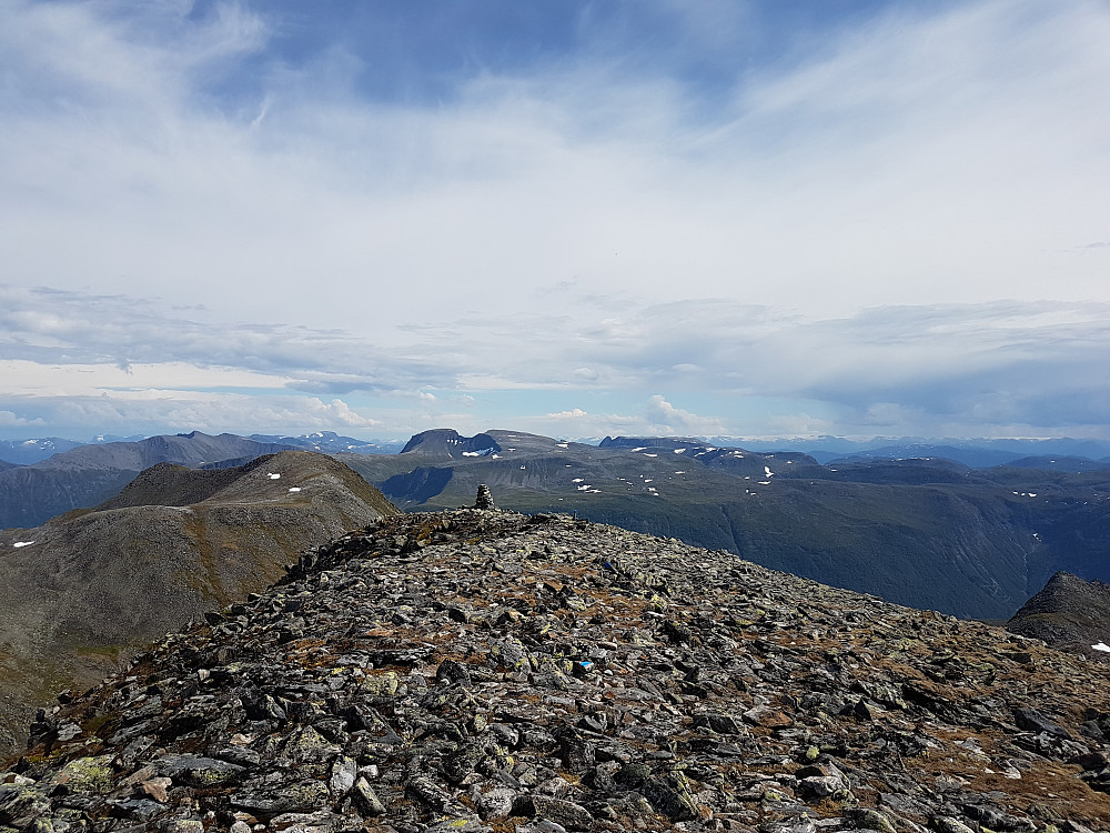 Utsikt øst; Trollvasstinden(rett over varde) og Eidskyrkja(til høyre/bak Trollvasstinden) sentralt. I det fjerne kan såvidt Lodalskåpa anes