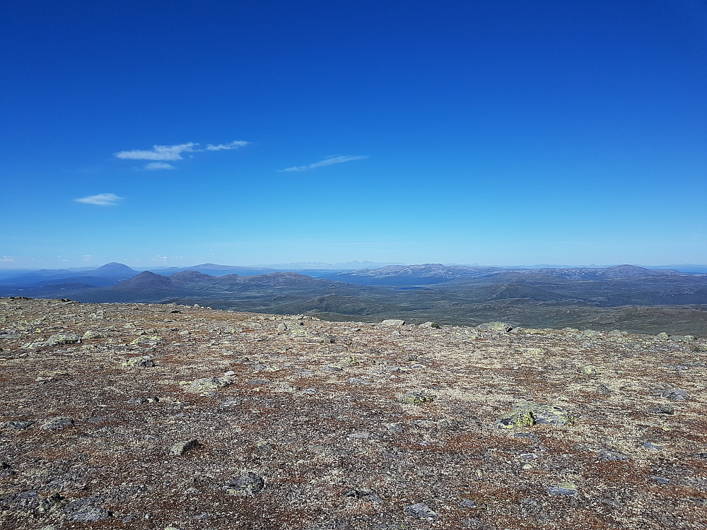 Utsikt nord. Heidalsmuen karakteristisk til venstre, Rondane kan skimtes sentralt i det fjerne. Elgspiggen(?) og Sølnkletten(?) høyre horisont? 