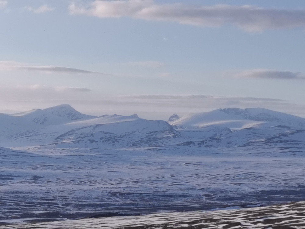 Trauste fjell " i syningom": Storstygge-Svånåtinden til venstre, Snøhettamassivet til høyre. Midt mellom de to stikker Langvasstinden og Larstinden opp.