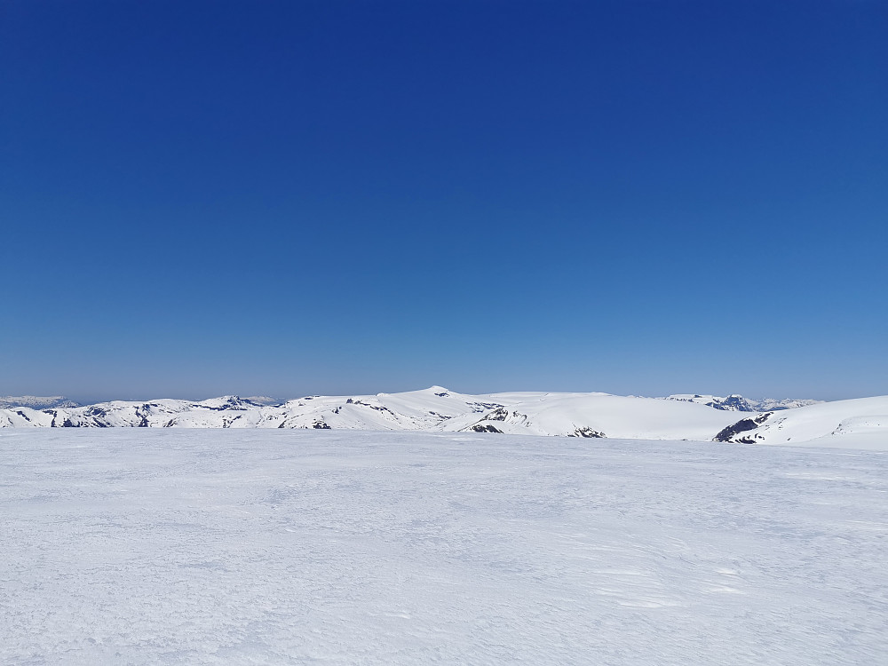 Utsikt nord. Snønipa naturlig blikkfang. Tinder på Sunnmøre kan skimtes i det fjerne til høyre. Den markerte tinden foran disse i høyre bildekant er Ceciliekruna