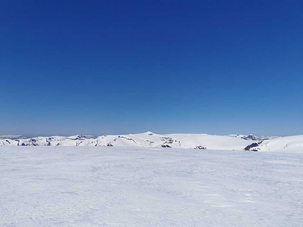 Utsikt nord. Snønipa naturlig blikkfang. Tinder på Sunnmøre kan skimtes i det fjerne til høyre. Den markerte tinden foran disse i høyre bildekant er Ceciliekruna 