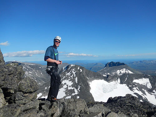 Ivar nyter toppen av Mesmogtinden. Kvitskardstind og Torfinnstinder danner flott bakgrunn.
