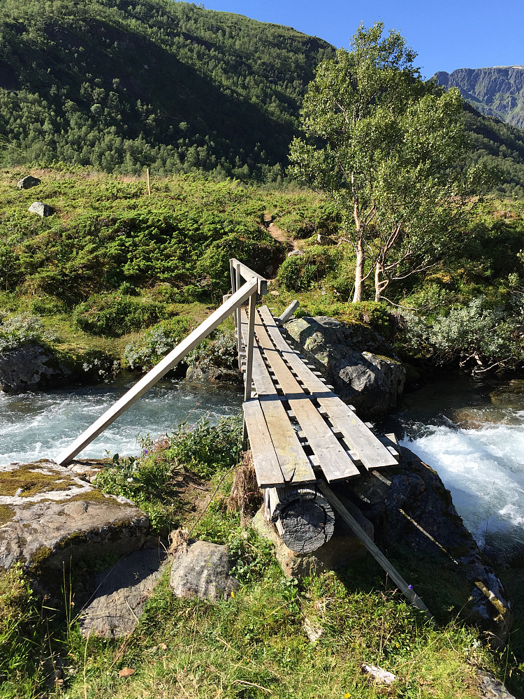 Man følger skiltingen til høyre, krysser denne broa, går over et myrparti der man har lagt ut gode gangbroer før man til slutt ender opp på stien oppover skogen. 
