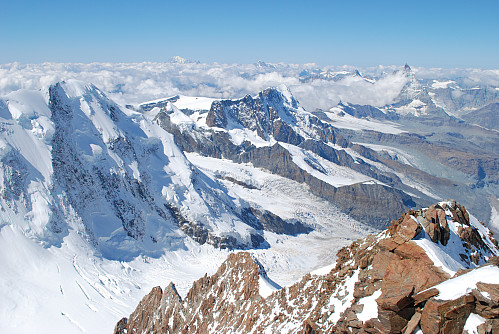 Utsikt vestover fra toppen, mot toppeggen vi kom opp. Til venstre i horisonten seen Mont Blanc. Matterhorn sees litt til høyre i bildet med noen skyer rundt.