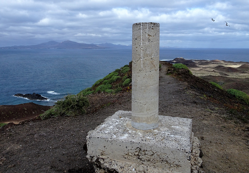 Trigpunktet på toppen, Lanzarote i bakgrunnen