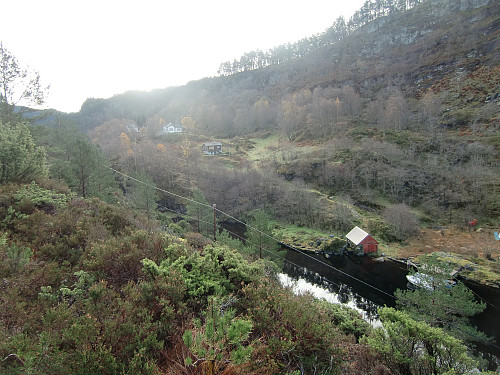 Gården Haugo og noen fritidshus sett fra stien til Drangen