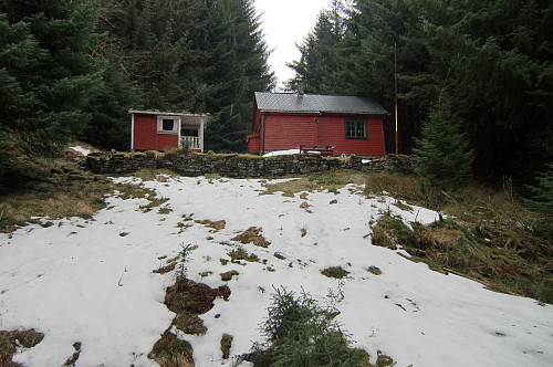 Hjelpekorpshytten ble bygget i 1954 av Fana Røde Korps Hjelpekorps. I dag står det et Airbnb skilt nedenfor hytten. 
