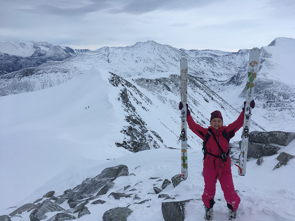 Fornøyd 13 åring oppunder toppen. Sist hun var her oppe var hun 11 år. Vi satte fra oss skiene og gikk på føttene opp siste biten. De tre neste tindebestigerne denne dagen skimtes i bakgrunnen.