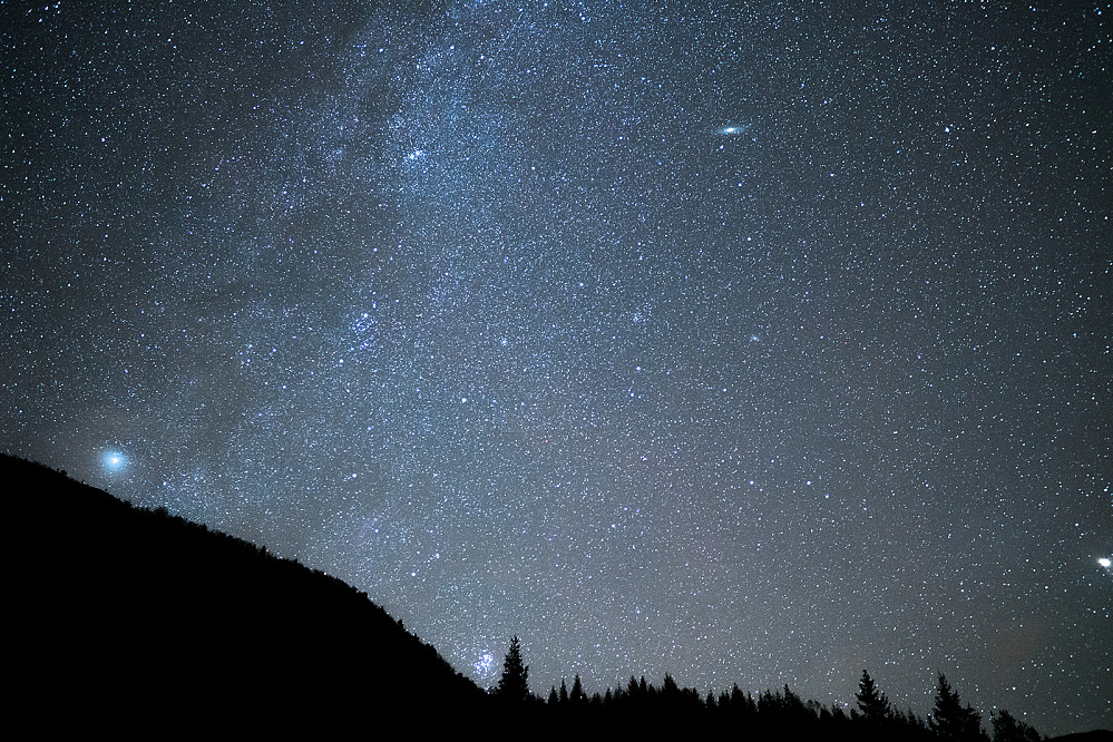 Utsikt mot Andromeda-galaksen (litt til høyre øverst) og Pleiadene (nede til venstre for treet). Er litt usikker på resten.  