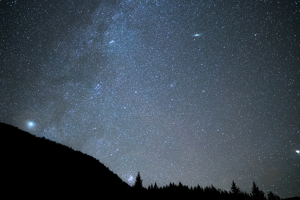 Utsikt mot Andromeda-galaksen (litt til høyre øverst) og Pleiadene (nede til venstre for treet). Er litt usikker på resten.