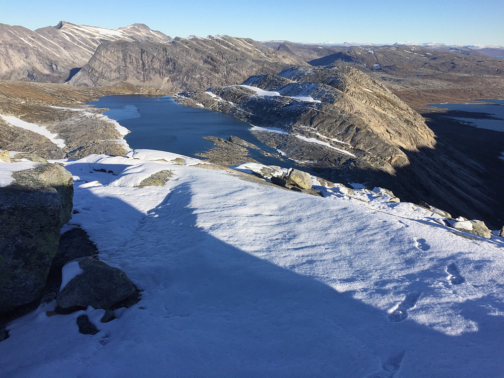 Tilbake mot Hálljejávrre. Stien sees godt som en tynn hvit strek av snø langs hele vannet på østsiden/til høyre i bildet