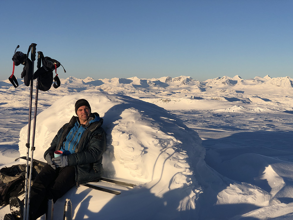 Toppvarden med naturlig benk for rast. Morten nyter sola i femten, seksten blå. Godt med litt varm drikke da.