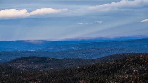 Spotlys over fjerne fjell i øst i kvelden