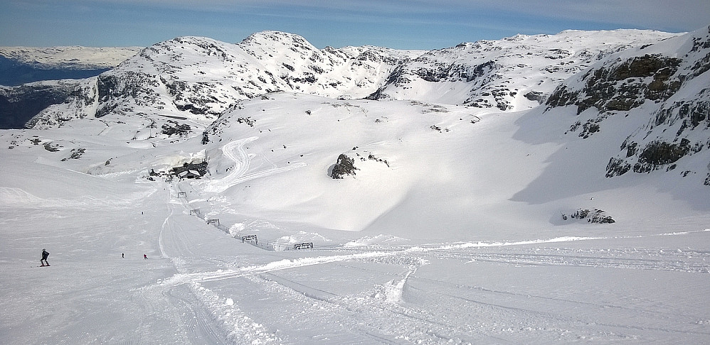 Ser ned skibakken. Skitrekket forsvant delvis under snøen et stykke, og en gravemaskin sto høyt oppi flanken. Den hadde nok gravet fram skitrekket, slik det sto i nyhetene nylig. Snakk om store snømengder.