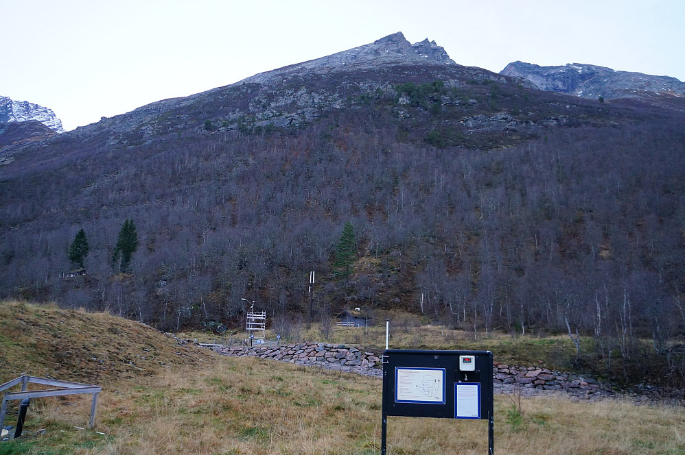 Fra parkeringa er det bare 2,1 km i luftlinje til toppen, men 1150 hm. Toppen ligger noe bak ganske til høyre i bildet. De to "finnene" er på sørryggen - sentralt i bildet, bak en skarp høyde.