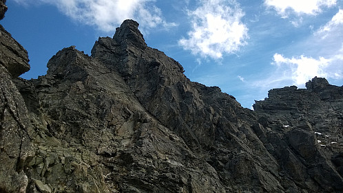 Dette er nordtoppen/nordspiret. Denne kan omgås et stykke ned i vestflanken - hvor bildet er tatt, om man vil spare tid. Det finnes varding her. Det som kan se ut som en topp til høyre i bildet, er bare en høyde på egga mellom nordtoppen og Dronninga.