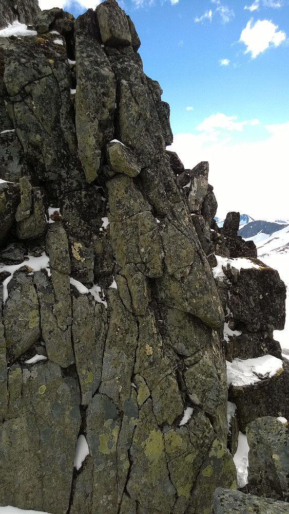 Rett ned egga i skaret er det nok klatring a grad 2+, men omgåelsen til høyre her (vestsida) gjør det mye lettere, og en gul trekant holder som markering. Tau trenges ikke på tørt fjell om en er litt vant med klyving i høyden, mener jeg.