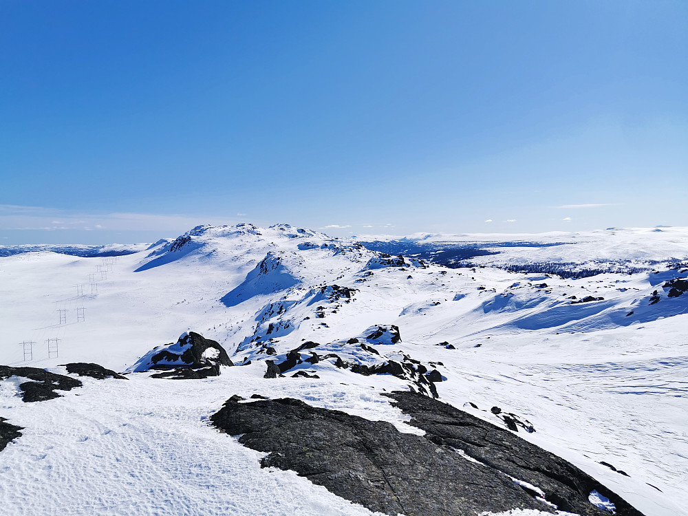 Utsikt fra toppen av Jøransetfjellet mot Fauskofjellet i enden av den småkuperte fjellryggen.