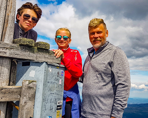 AndreasBO, NellieHF og GlennWO poserer ved stolpen som er satt opp ved siden av toppunktet på Gaustatoppen.