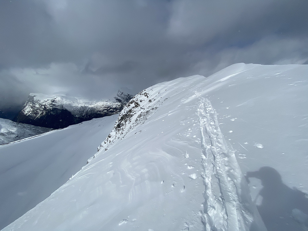 De siste 50 meterne bort til toppunkter smalner ryggen inn. Sånn snøen lå i dag var det grei helling mot stupet på venstresida og store skavler på høyre.