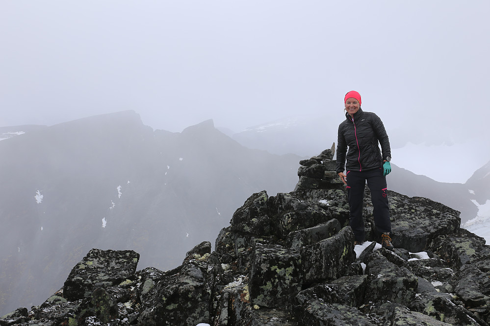 Lena trives med å ha nådd toppen av Vestre Skardstinden. I bakgrunnen ser vi Storgrovhøe og Storgrovtinden.
