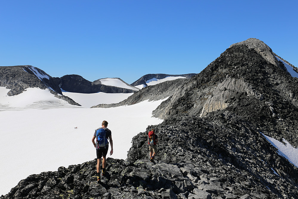 Toppsankerne vanker oppe i høyden blant vardene, mens resten av gjengen valgte den behagelige ruta over breen mot Bukkeholsbandet og en pause i sola. Nørdre Bukkeholstind nærmer seg.