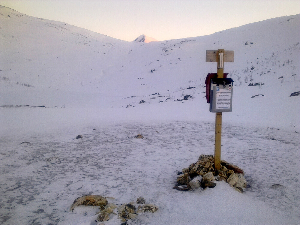 Krokvatnet under snø og is.Tromsdalstinden skimtes over åsen.