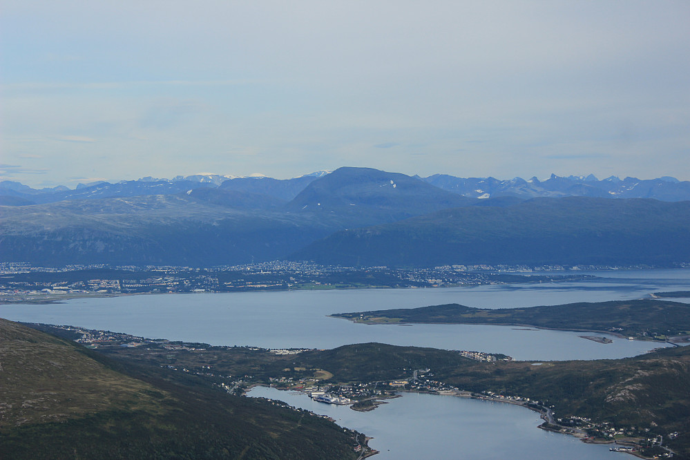 Mot Tromsø og fastlandet med Tromsdalstinden sentralt i bildet.Fylkets høyeste fjell ( rett bak Tinden) Jiehkkevarri 1833 moh.