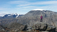 Kristine på toppen av Knutshøe, med Surtningssue og Besshøe bak