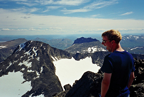 22.07.2000 - Hans Petter på Mesmogtinden (2264). Nærmest til venstre er Kvitskardtinden (2193). Torfinnstindene ses lenger bak midt i bildet.