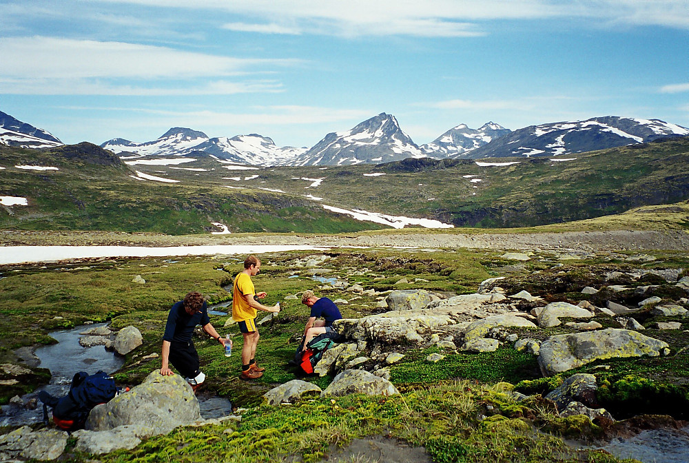 23.07.2000 - Vi fyller opp vannflaskene i en liten bekk på et flatere parti sør for Veslådalen, litt sør for høyde 1348. Bildet er tatt nordover, med Semeltinden (2236) i midten.