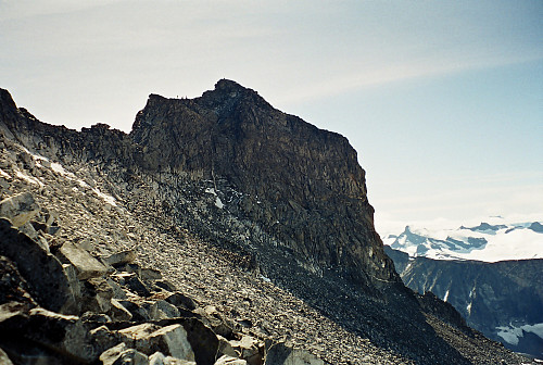 12.08.2000 - Ymelstinden (2304) sett fra ura i vestsiden på Storjuvtinden (2344). Fire personer kan ses oppe på ryggen til venstre for toppen.