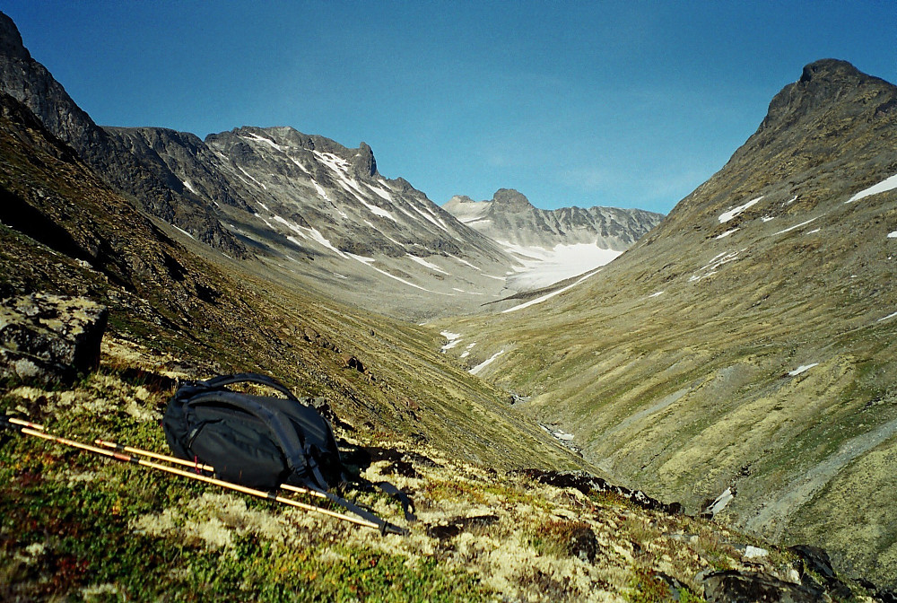 12.08.2000 - Rett før jeg bikker ned i Leirdalen, ser jeg tilbake mot dalen jeg nettopp har gått nedover og tindene jeg besteg denne dagen. Nede til høyre renner Nørdre Illåe. Skardstinden (2373) og Nåle (2310) ruver i bakgrunnen til venstre. Helt bakerst og midt i bildet ses Storjuvtinden (2344), med Ymelstinden (2304) litt til høyre for denne.