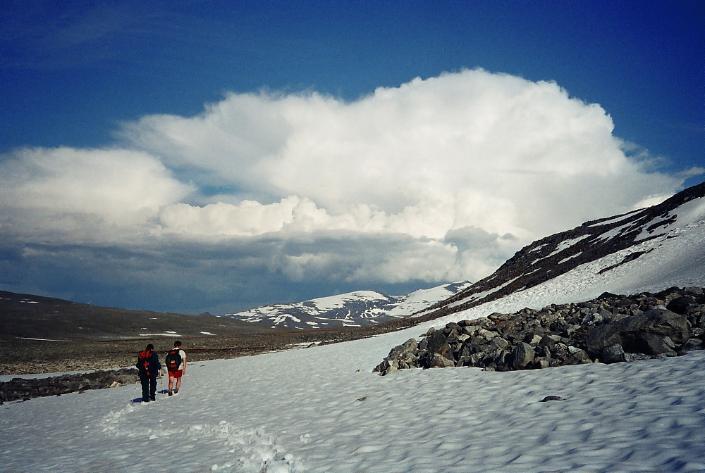 07.07.2001 - Vandring østover i Trollsteinkvelven. Austnubben (2049) og Stornubben (2174) blir små mot de høye bygeskyene lenger øst.