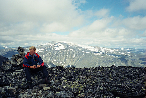 28.07.2001 - Ved toppvarden på Søraustre Styggehøbreatinden (2232). Glittertinden (2460) lyser opp i bakgrunnen med sin hvite toppkrone.