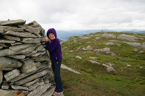 14.07.2015 - Julie ved varden på Byfjellenes høyeste punkt (674). Bak til høyre er Hauggjelsvarden (673).