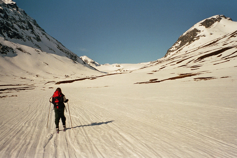 20.04.2002 - Grete på vei oppover langs Tverråe. Styggehøe (2213) stiger høyt opp i venstre bildekant. Lenger bak, midt i bildet, ligger Tverråbrean, med Nørdre Bukkeholstinden (2149) litt til venstre.