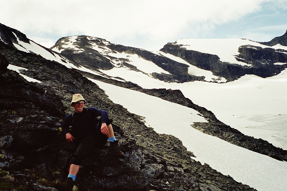 21.07.2002 - Vi er i vestsiden på Rundhøe (1822). Nedenfor oss, helt til høyre, er litt av Storbrean. I bakgrunnen, rett over Hans Petter, ses Geite (2002).