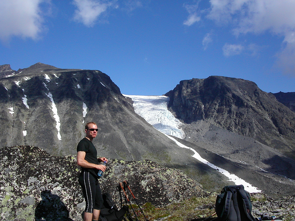 05.07.2003 - Per Rune på bandet øst for høyde 1562, hvor man går ned i Øvre Russglopet, som er nede i dalen til høyre. Fjellet til høyre for brefallet fra Surtningssubrean er Nestaustre Surtningssue (2033). Vi gikk opp i renneformasjonen helt til høyre for å komme opp på den toppen. Oppe til venstre er Midtre Surtningssue (2251). Sørtoppen (2302) på Surtningssue stikker fram bakerst i venstre bildekant.