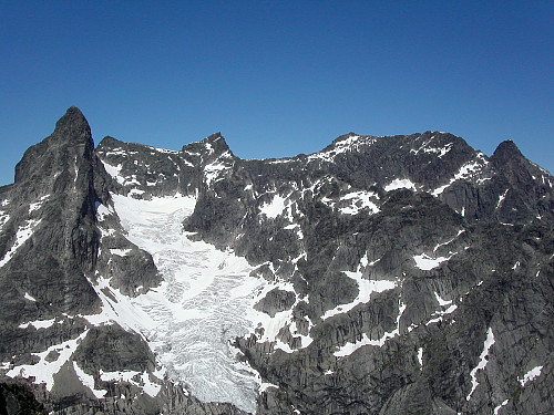 13.07.2003 - Norges høyeste alpine fjellrygg sett fra Midtmaradalstindane. Storen (2405) rager steilt til værs helt til venstre. Sentraltinden (2348) er litt til venstre for midten, og Styggedalstindane (2387) noe til høyre i bildet. Gjertvasstinden (2351) ses lengst til høyre.