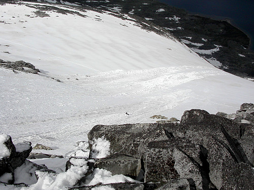 11.07.2004 - Nokså sentralt i bildet ses Ragnar som aker nedover med en del sørpe og våt snø i nordsiden på Skarddalseggje (2159). Dette er på den lille breen/fonna som er inntegnet på kartet like N/NØ for toppen.