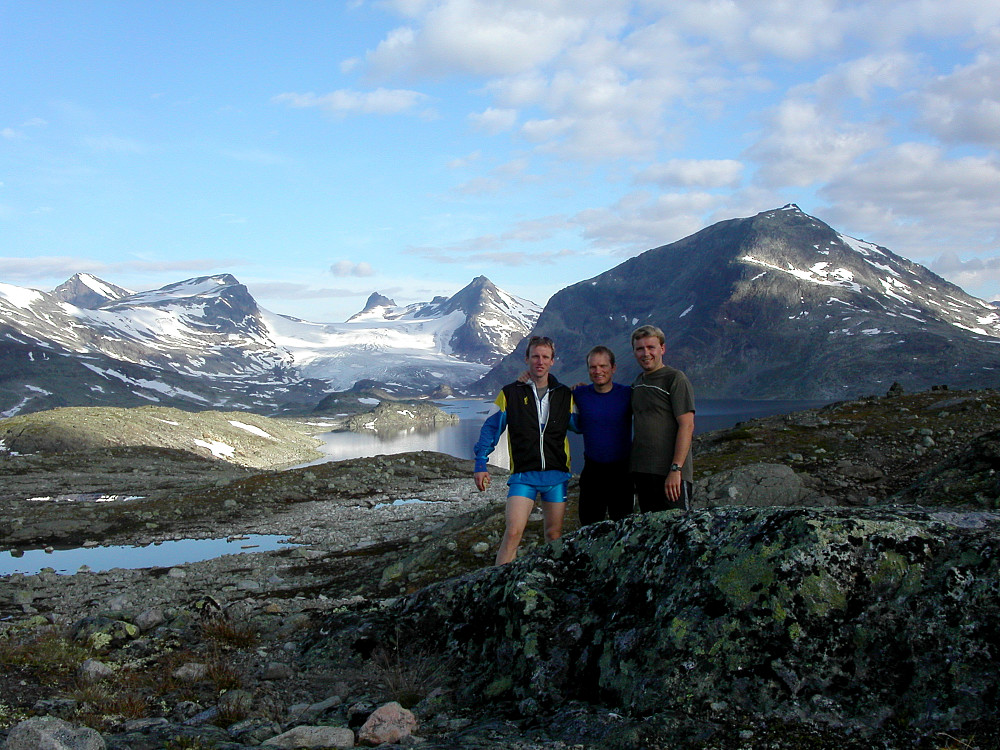 31.07.2004 - Hele turfølget med dagens mål langt bak midt i bildet. Fjellet til høyre er Storegut (1968). Rett bak oss er Store Mjølkedalsvatnet. 