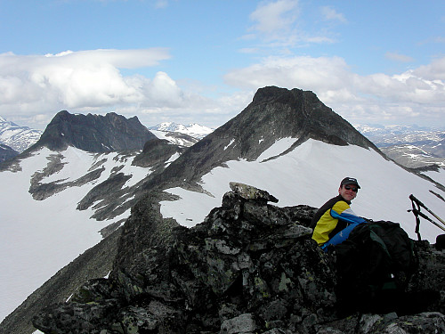 31.07.2004 - Hans Petter sitter på Sørøst for Mjølkedalspiggen (1987). Fjellet bak til høyre er Mjølkedalspiggen (2040). Lenger bak til venstre ses Sagi (2040).