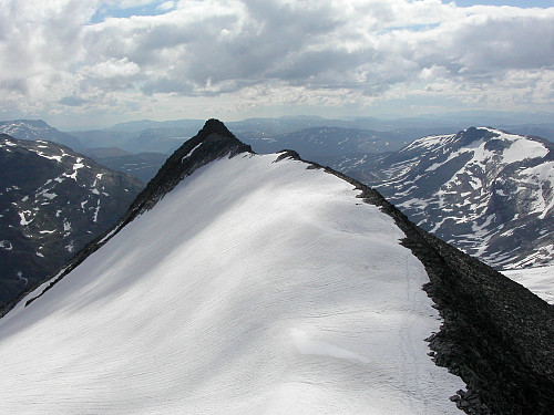 31.07.2004 - Vi nærmer oss toppen av Mjølkedalspiggen (2040) og ser tilbake mot Sørøst for Mjølkedalspiggen (1987). Våre spor kan ses helt til høyre på snøen nedenfor.