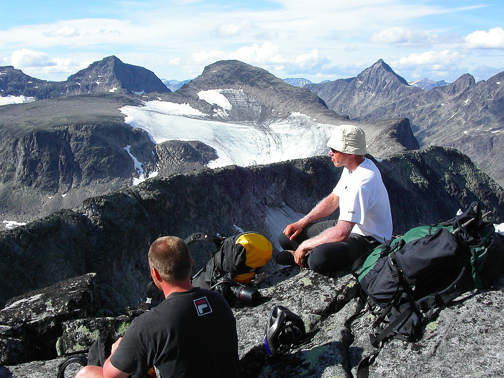 26.07.2006 - Vi slapper av og nyter utsikten fra Vestre Torfinnstinden (2085), etter en spennende travers over Torfinnstindane. Midt i bildet bak er Kvitskardtinden (2193). Til venstre for denne ses Mesmogtinden (2264). I bakgrunnen til høyre rager Store Knutsholstinden (2341) opp.