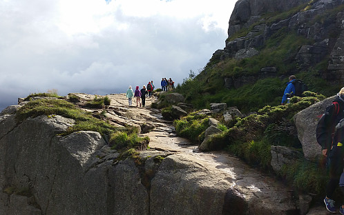 06.08.2016 - Vi nærmer oss Preikestolen. Julie (med turkis fleecejakke) og Frida (lilla fleecejakke) på stien foran. Jeg kommer traskende til høyre med blå jakke.